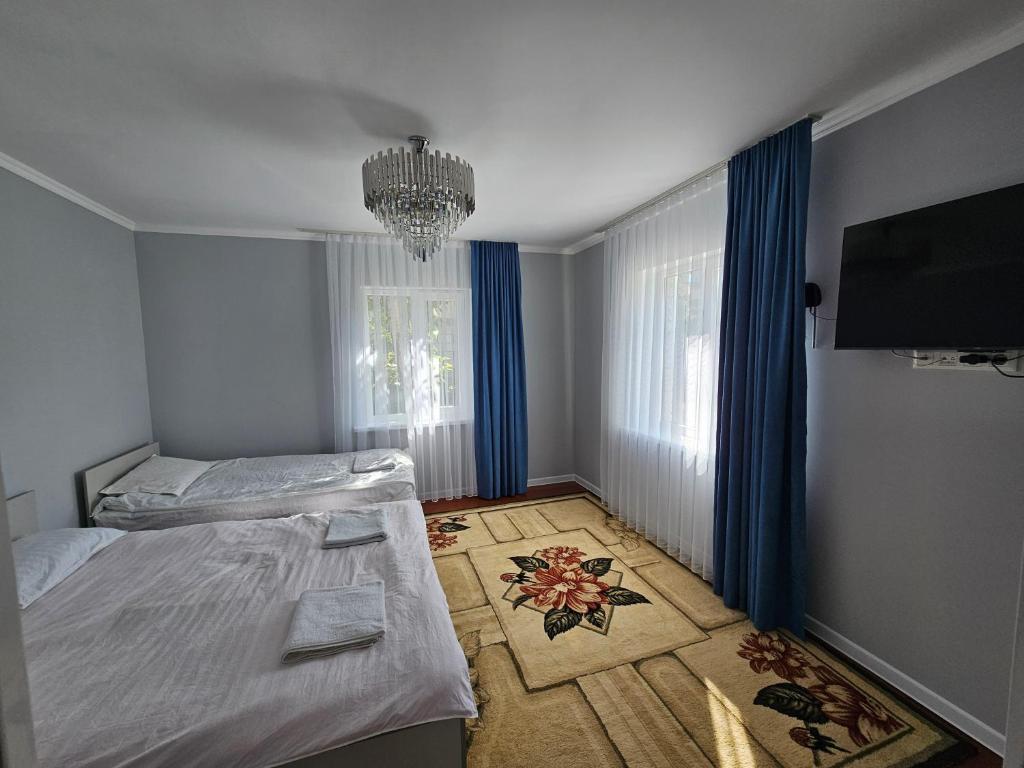 a room with two beds and a chandelier in it at Близняшки in Kaji-Say