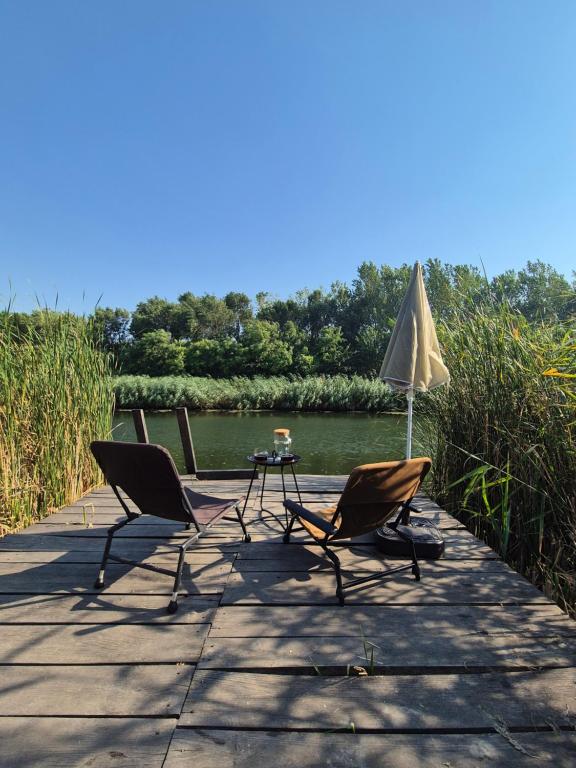 two chairs and a table and an umbrella on a dock at Avalon Mali Stapar 