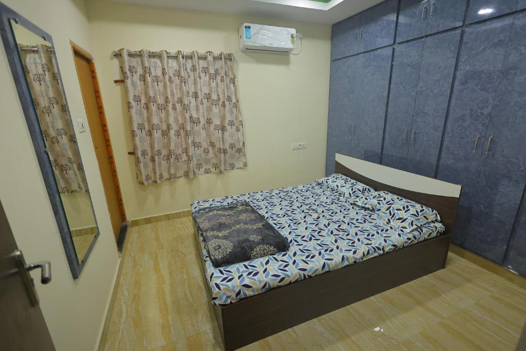 - un petit lit dans une chambre avec rideau dans l'établissement Newly built spacious and luxurious 2bhk with scenic hill views in tirupati, à Tirupati