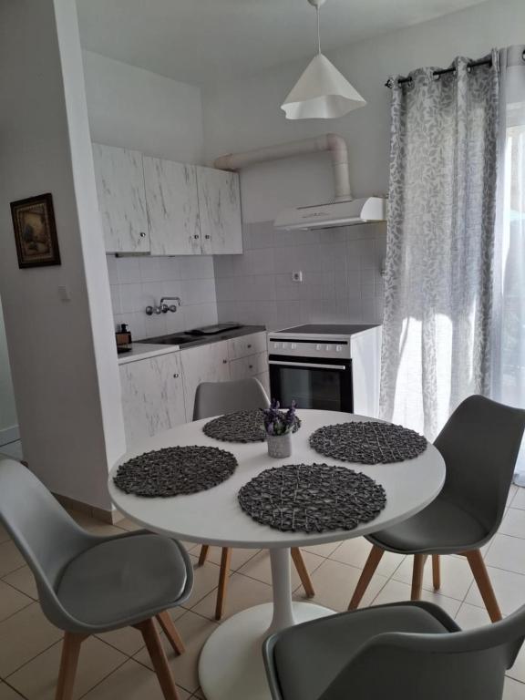 a kitchen with a table and chairs in a kitchen at Angel's apartments in Panayía