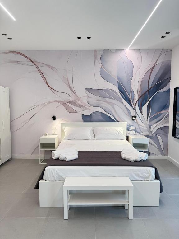 a bedroom with a large bed with a painting on the wall at Meraviglia B&B - Salerno Centro Close to the Station and Pier in Salerno