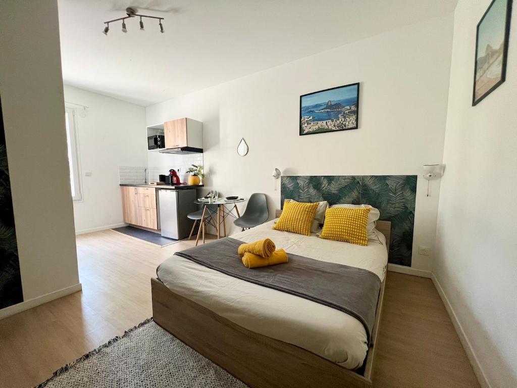 ein Schlafzimmer mit einem Bett mit einem gelben ausgestopften Tier darauf in der Unterkunft Studio Rio - Confortable avec jardin d'été I proche gare et centre in Châtellerault