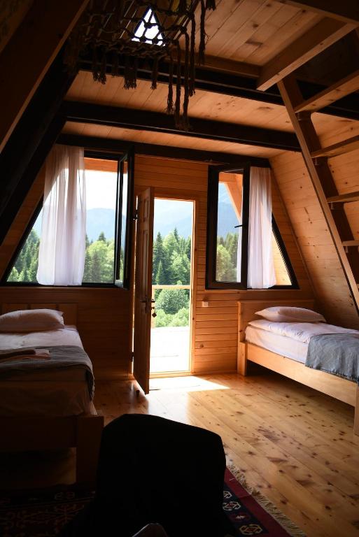 a bedroom with two beds and a large window at Kirari Mount Camp in Zemo-Margi
