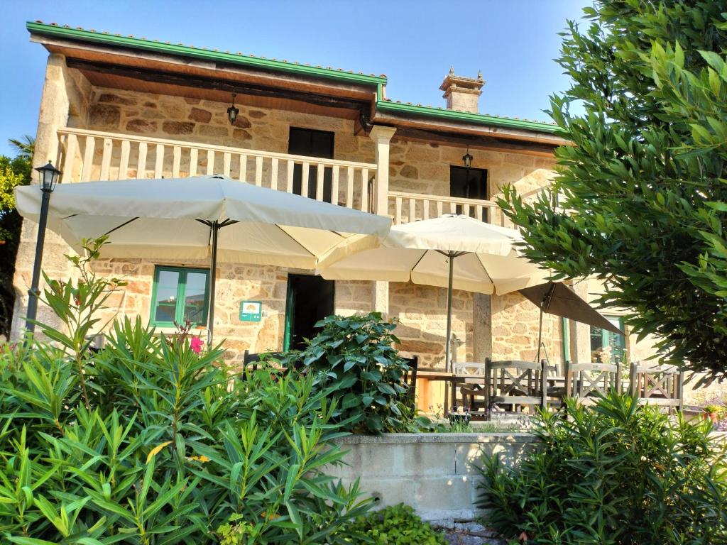 a house with two umbrellas in front of it at alma de quireza in Santo Tomé