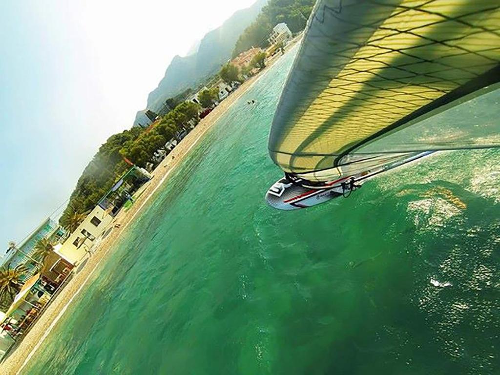 a boat is flying over the water near a beach at Kate Apartments in Kokkari