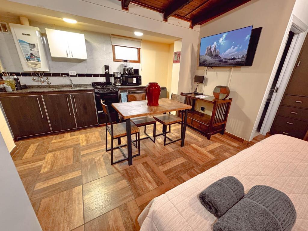 een kamer met een keuken, een tafel en een bed bij LA CASA DE FRIDA in Ushuaia