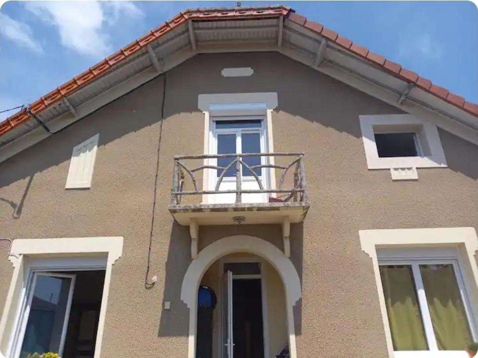 a building with a balcony on the side of it at Grande maison de bourg in Montpon-Ménestérol