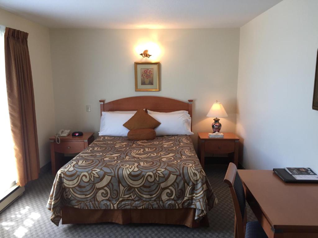 a hotel room with a bed and a desk at Motel Du Chevalier in Gatineau