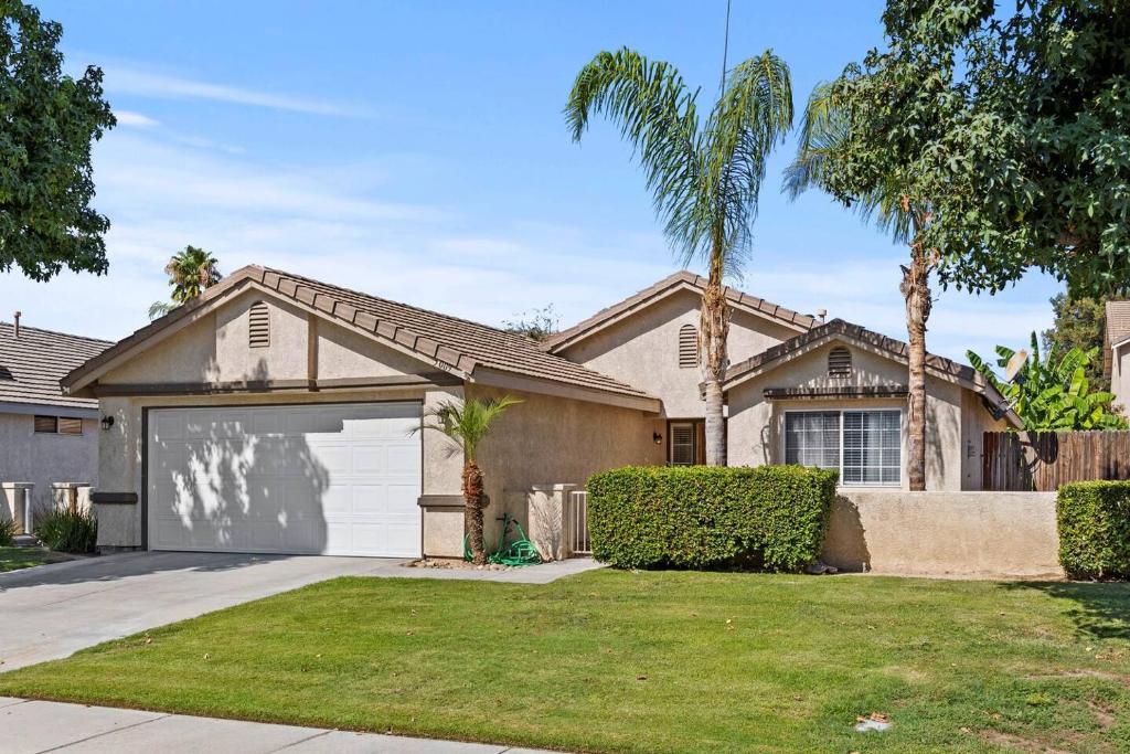 ein Haus mit Garage und Palmen in der Unterkunft Modern Southwest Escape 2 Master Bedrooms in Bakersfield