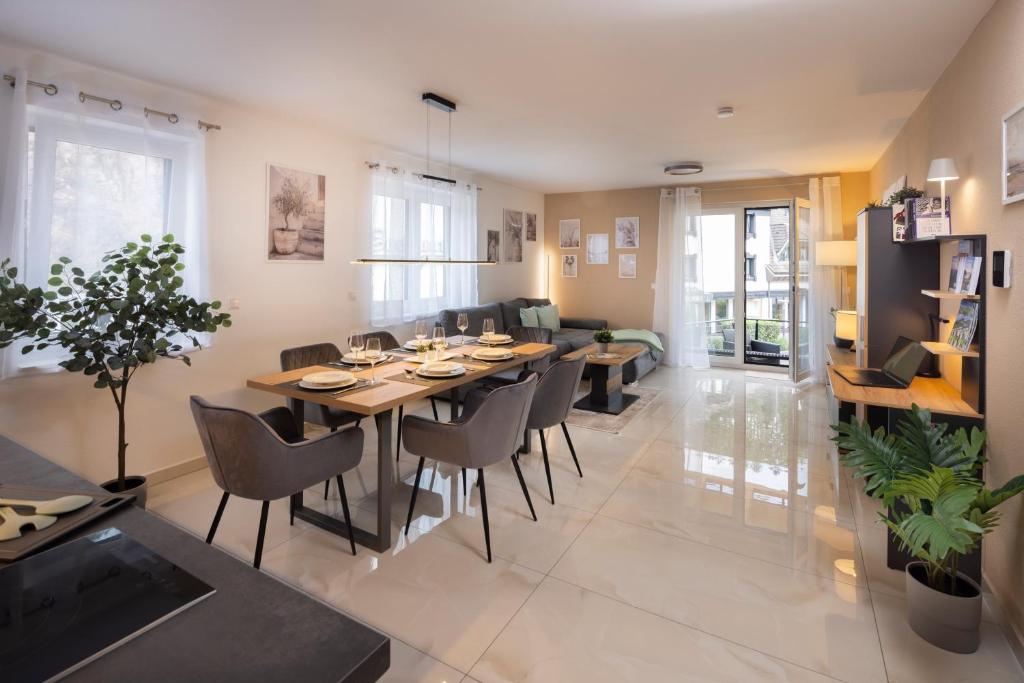 a dining room and living room with a table and chairs at Blue Sky Flat, Apartment, 73qm, 4-6 Personen, Neubau Süd-Balkon mit Lounge-Möbeln, Schwarzwald-PLUS inkl 80 Gratis-Attraktionen täglich in Baiersbronn