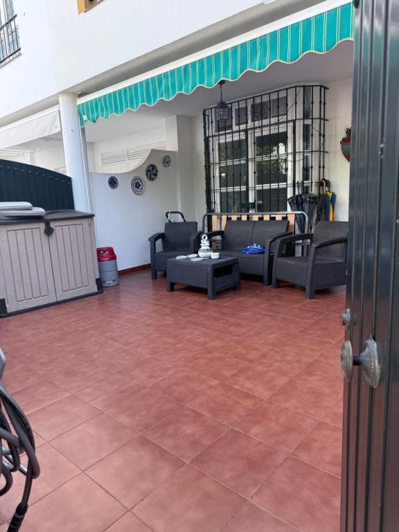 ein Wohnzimmer mit Sofas und eine Terrasse in der Unterkunft Casa Coplas muy cerca de la playa in Sanlúcar de Barrameda