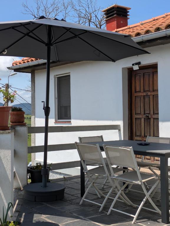 a table and chairs under an umbrella on a patio at Alvares de Corvera in El Pontón