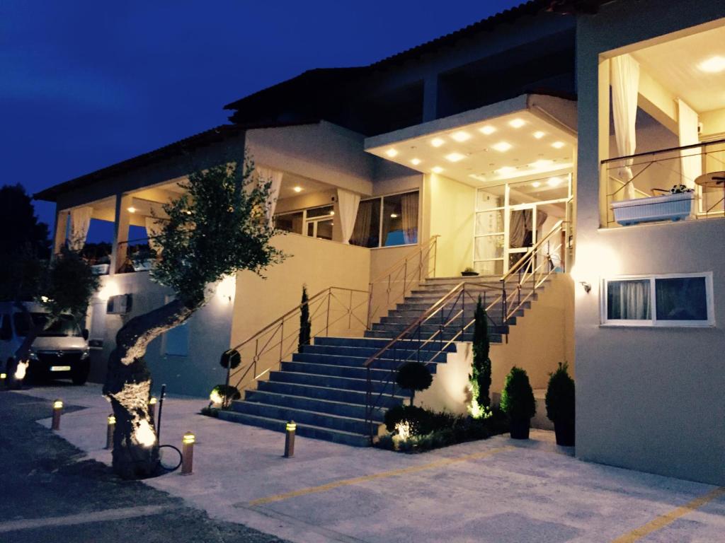 a house with stairs in front of it at night at Thea Hotel in Possidi
