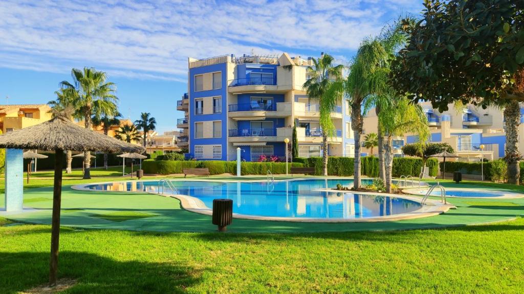 a swimming pool in front of a building at Apartamento Punta Glea in Orihuela Costa