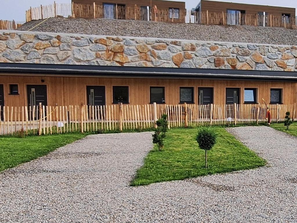 a house with a fence and a tree in the yard at Timos Camp in Nöchling