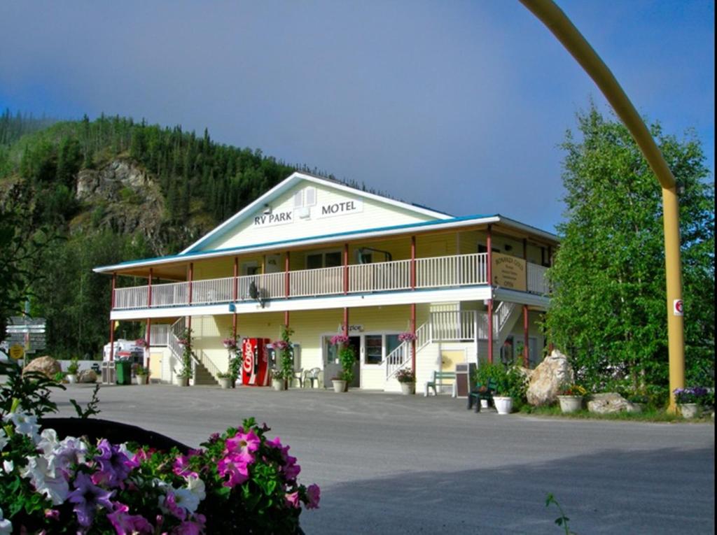 un grand bâtiment avec un grand parking fleuri dans l'établissement Bonanza Gold Motel, à Dawson City