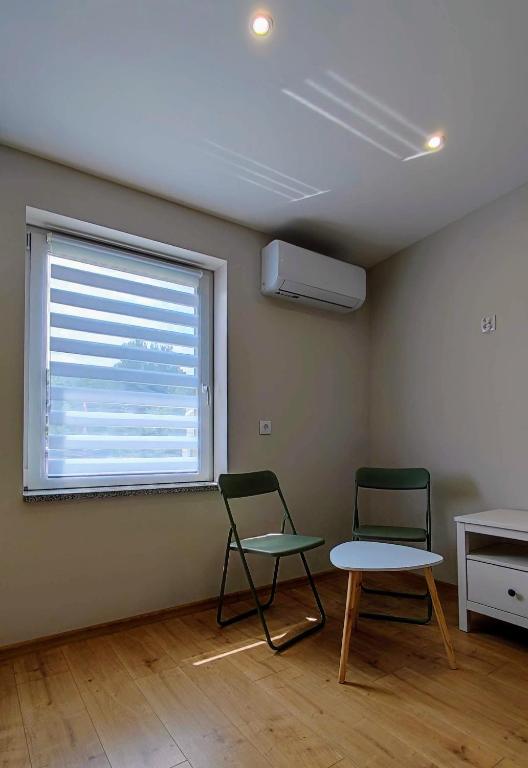 two chairs and a table in a room with a window at Apartament Wysoka 580 z prywatną łazienką in Bielawa