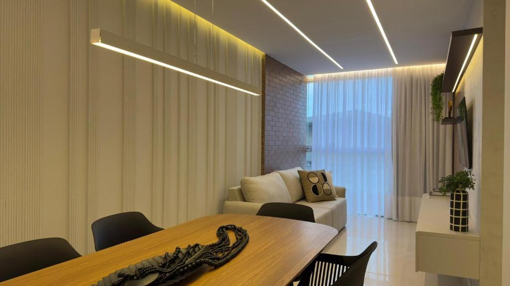 a living room with a table and a couch at Praia Luxo e Conforto in Vila Velha