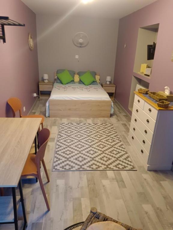 a bedroom with a bed and a dresser and a desk at fleurs de printemps - Jonquille chic in Vrécourt
