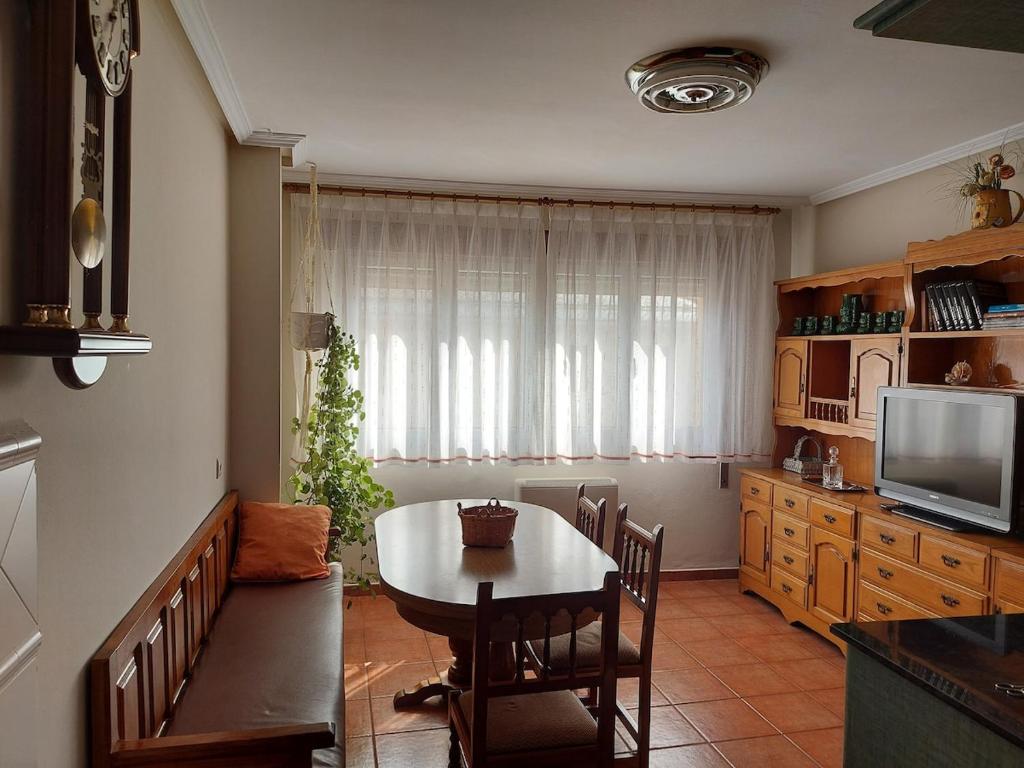 Una cocina y un comedor con una mesa y un televisor. en Alojamiento Sena VUT LE-1254, en Villablino