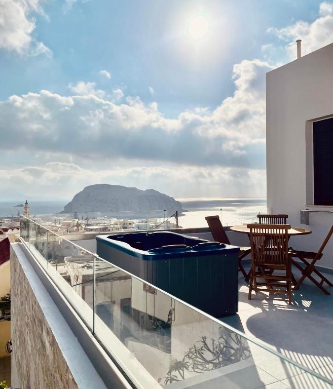 a hot tub on a balcony with a view of the ocean at Majestic View Villa - Outdoor Jacuzzi in Arkasa