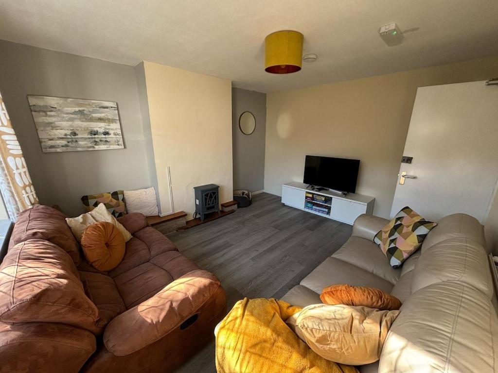 AylestoneにあるThe Stayover Spot Wigston Escapeのソファ2脚と薄型テレビのあるリビングルーム