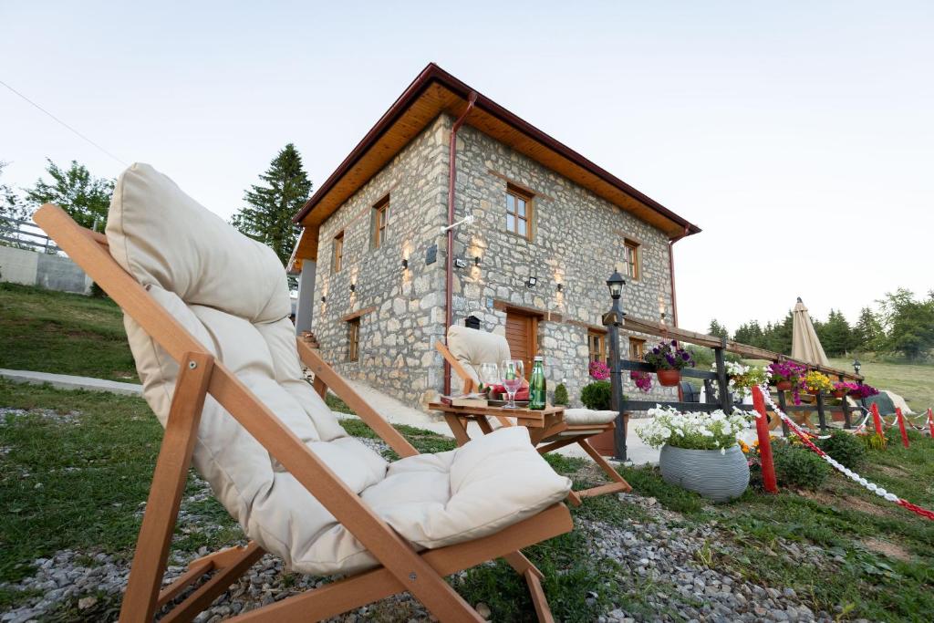 a couple of chairs sitting in front of a building at Kula 1960 Luxury Stone House in Rožaje