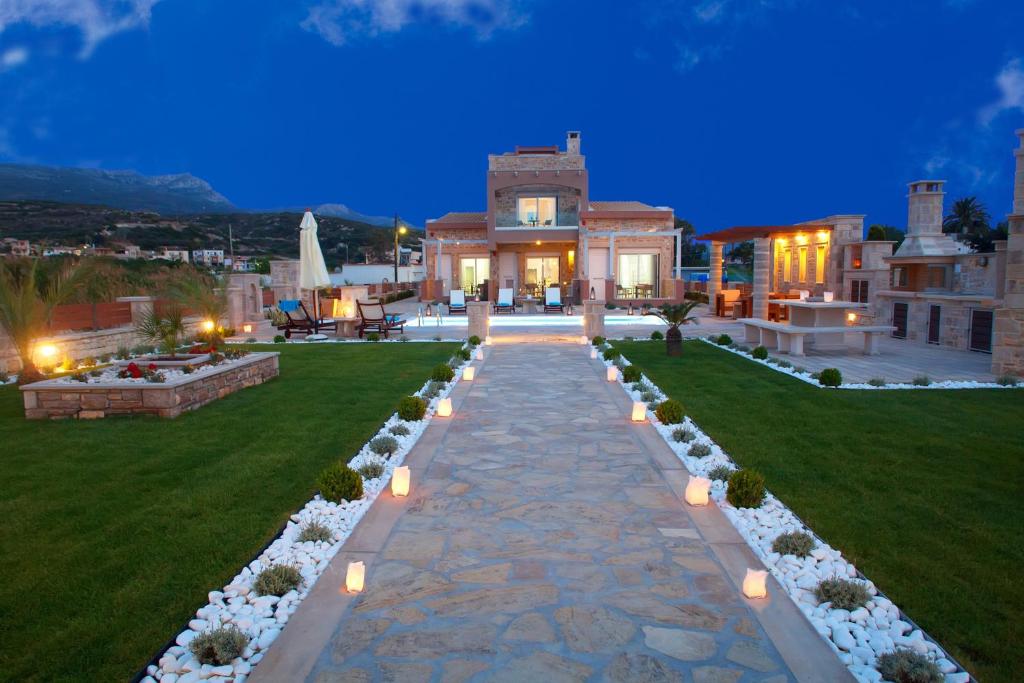a house with a pathway leading to a yard with lights at Blue Horizon Villa & Suites in Sitia