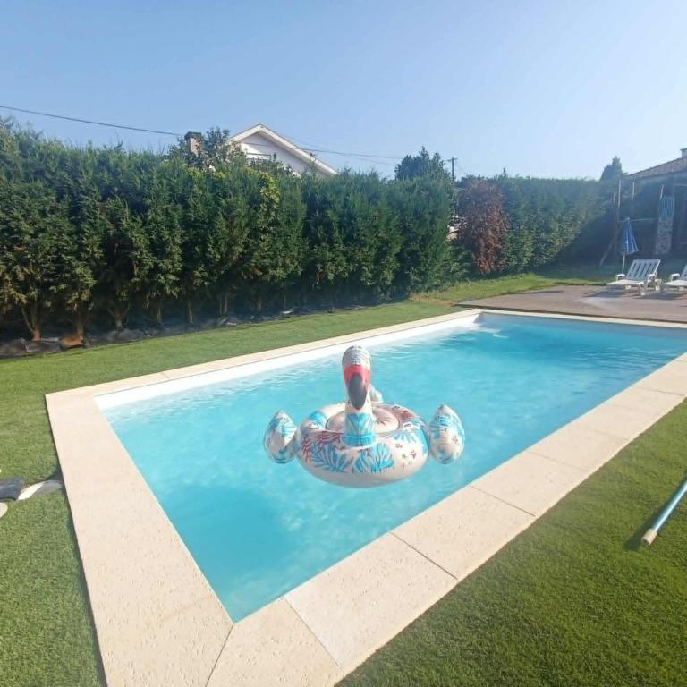 a man in an inner tube in a swimming pool at O Canto do Melro, Guest House in Cortegaça