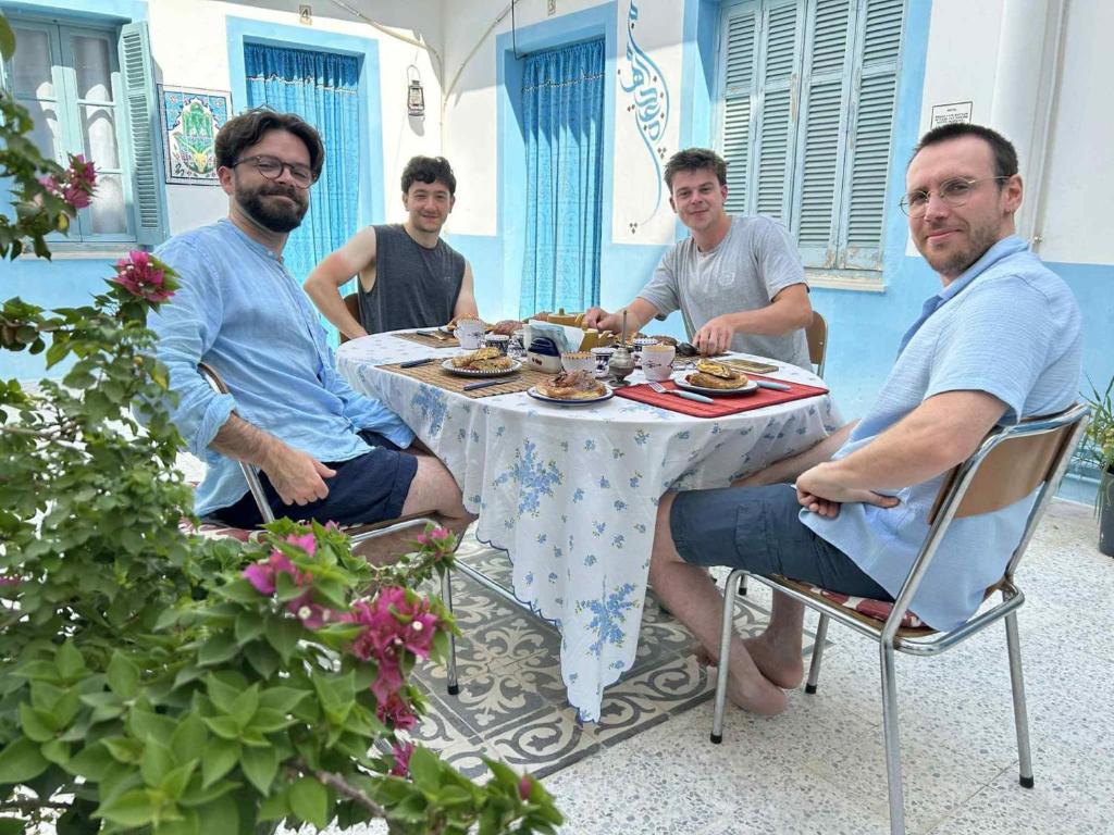 a group of men sitting around a table eating food at Dar Hkaïem in Hammam Sousse