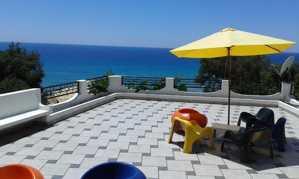 patio ze stołem, krzesłami i parasolem w obiekcie Akis Apartments Kontogialos-Pelekas w mieście Pelekas