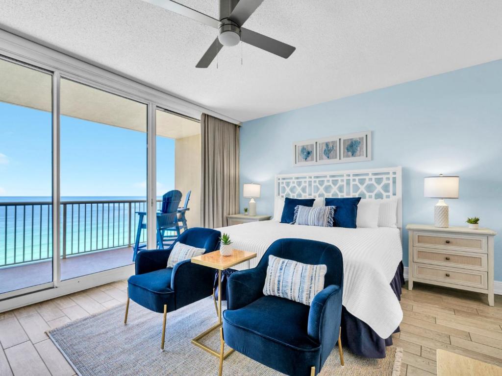 ein Schlafzimmer mit einem Bett und zwei blauen Stühlen in der Unterkunft New BeachFront-Majestic Beach Resort-Starbucks in Panama City Beach