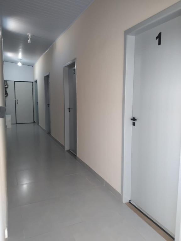 an empty hallway with white walls and a door at Pousada Santa Rita in Roseira
