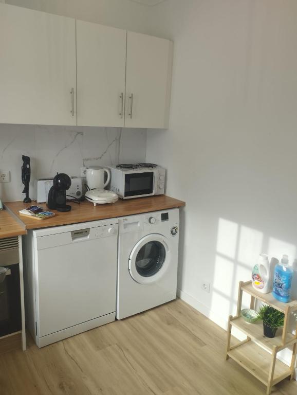 a kitchen with a washing machine and a microwave at Green Passion in Ponta Delgada