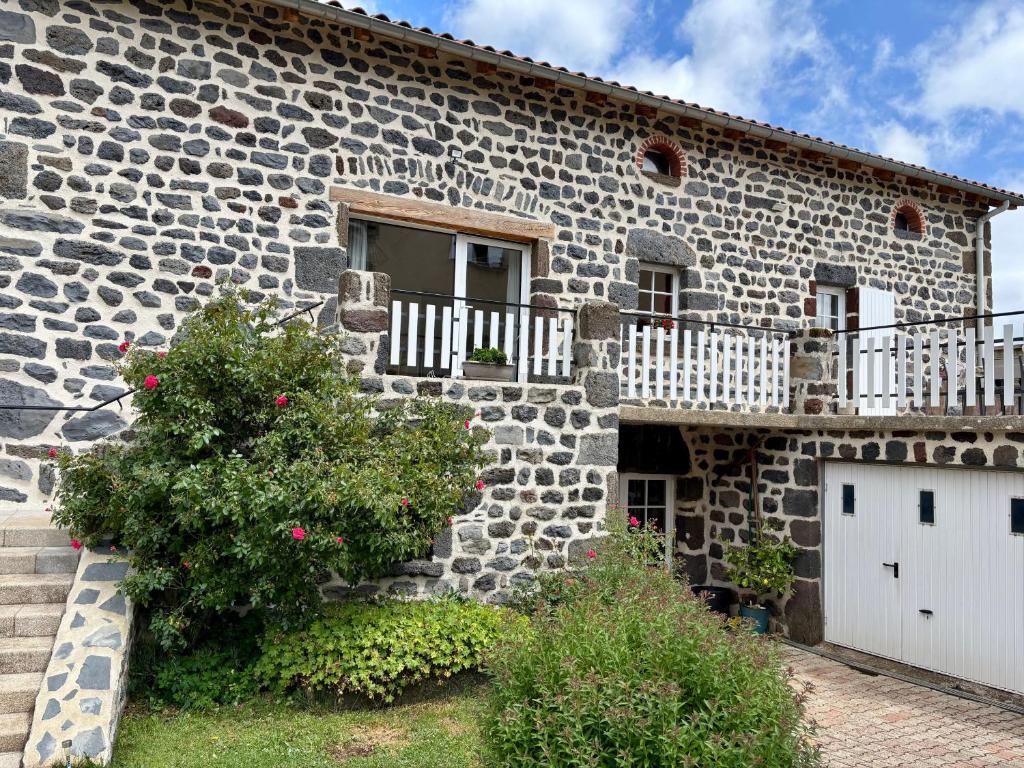 una casa in pietra con finestra e balcone di Gîte pittoresque en campagne près du Puy-en-Velay, idéal pour nature et St-Jacques de Compostelle - FR-1-582-451 a Séneujols