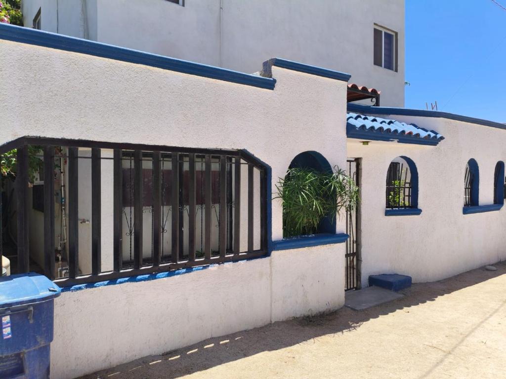 a white building with a gate and a potted plant at La casa del pescador in La Paz