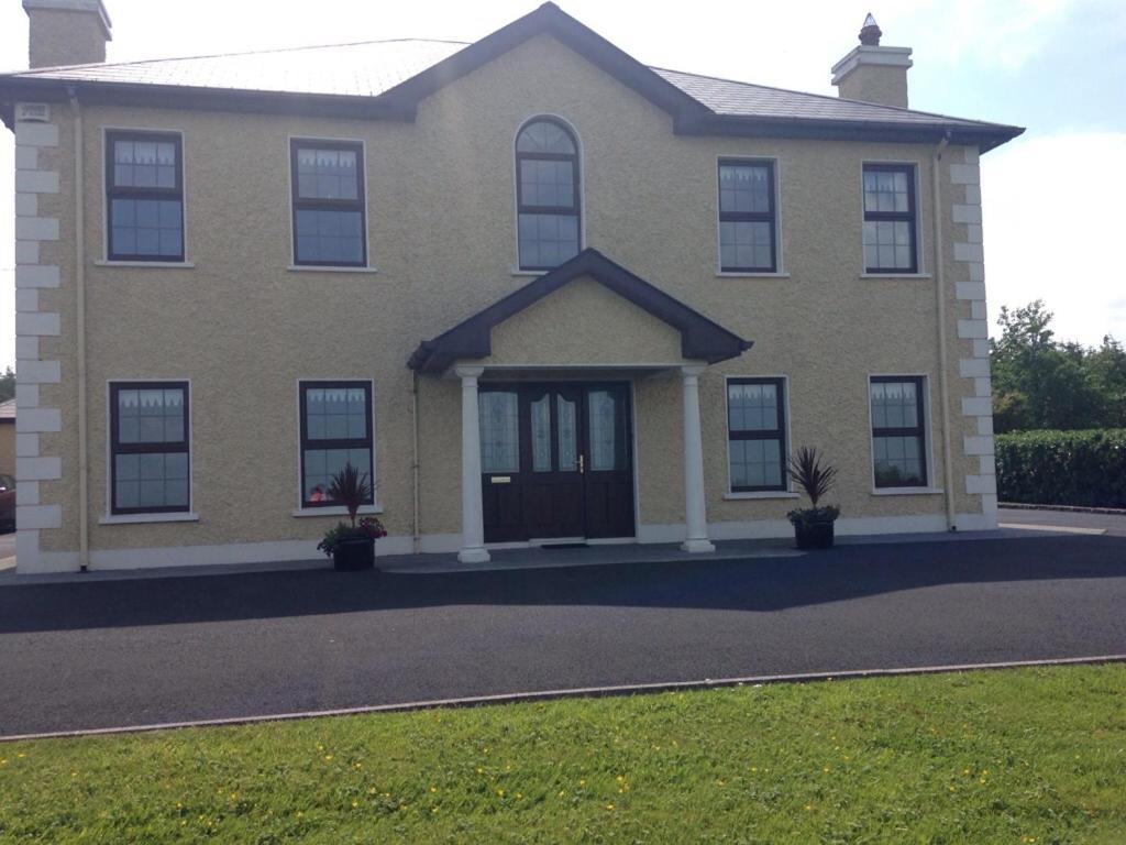 a large house with a front door and grass at Clonoughter Heights in Glin