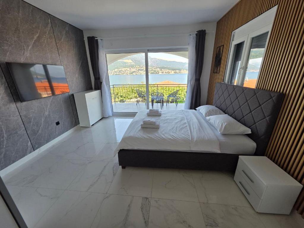 a bedroom with a bed and a large window at Maric Apartments Njivice Herceg Novi in Njivice