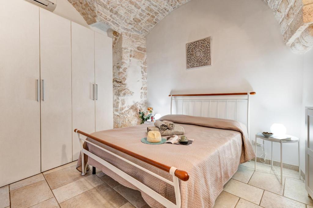 een slaapkamer met een bed in een witte kamer bij Maison de Antonelle in Ostuni