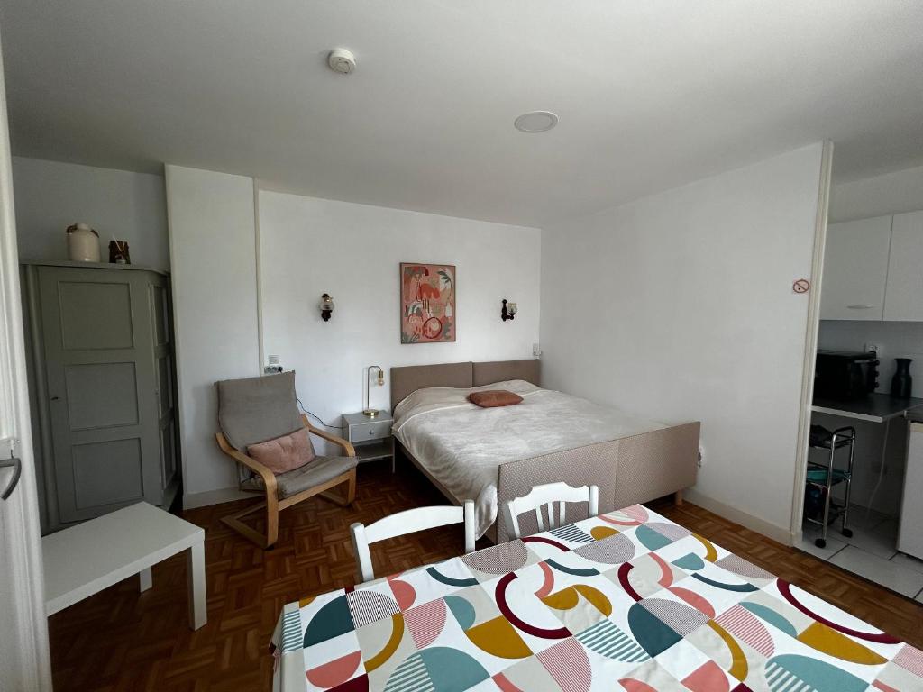 une petite chambre avec deux lits et une cuisine dans l'établissement Studio entre Thermes et centre-ville avec jardin, parking et WIFI - FR-1-541-119, à La Roche-Posay
