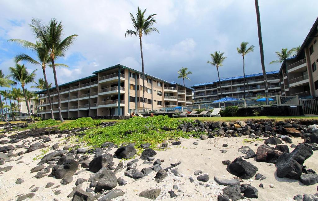 a pile of rocks on the beach in front of a hotel at CASTLE at Kona Reef in Kailua-Kona