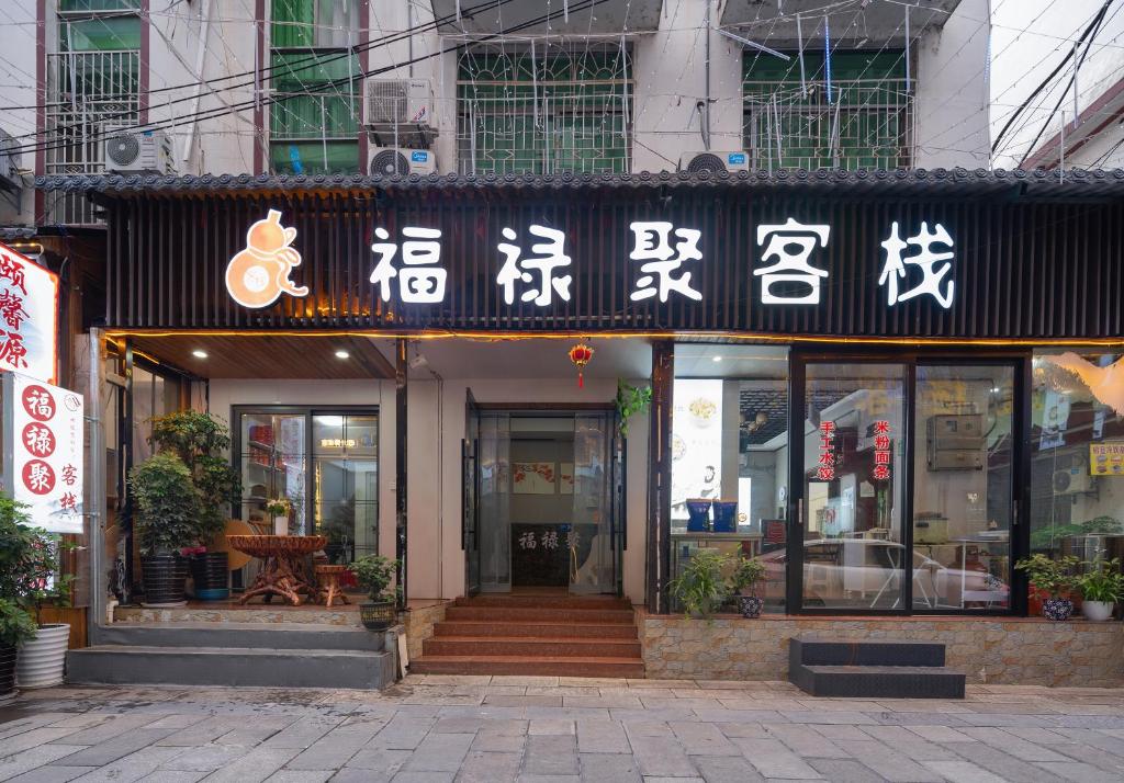a building with asian writing on the front of it at Zhangjiajie Fuluju Inn in Zhangjiajie