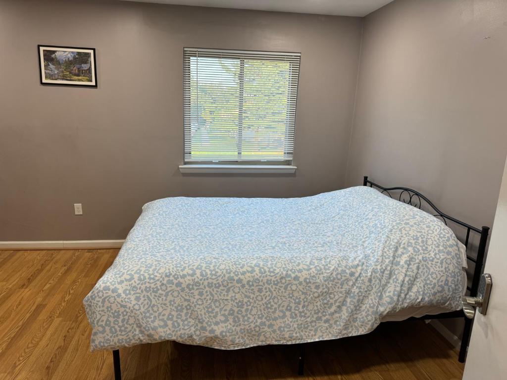 a bedroom with a bed with a blue comforter and a window at Near To CCBC ESSEX Private Room 201 in Parkville