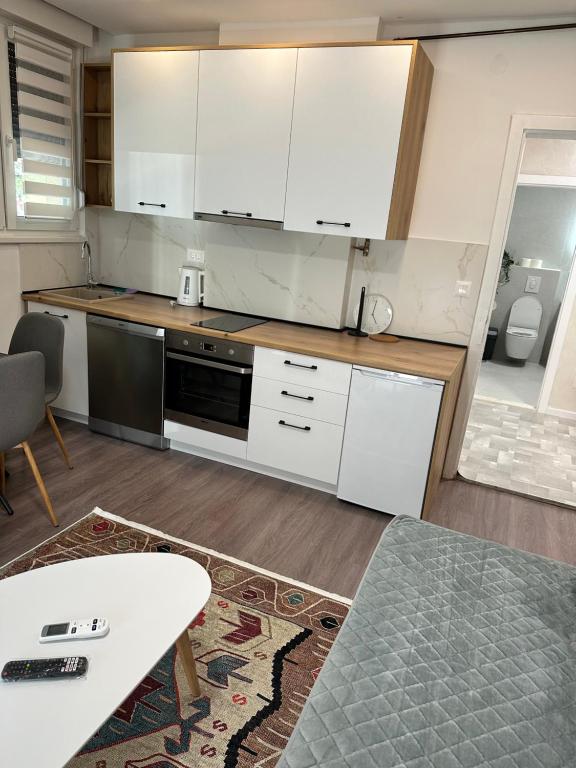 a kitchen with white cabinets and a table at Air Urban Ilidza Sarajevo Free Parking and Near Airport in Sarajevo