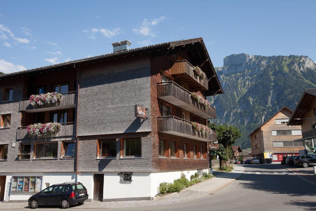 a building with flowers on the balconies and a mountain at Dorfgasthof Adler in Mellau