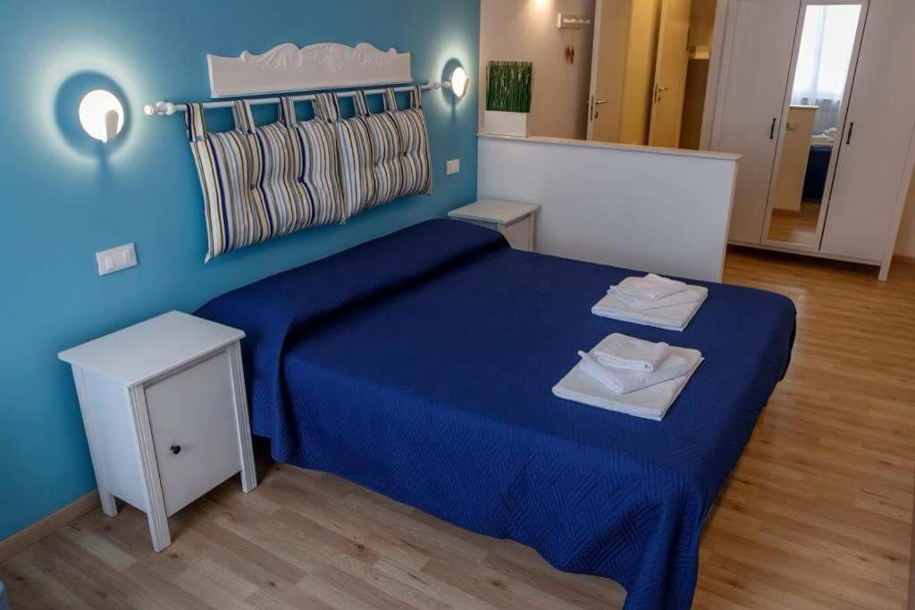 - une chambre bleue avec un lit et un mur bleu dans l'établissement Rosa Dei Venti, à Riomaggiore