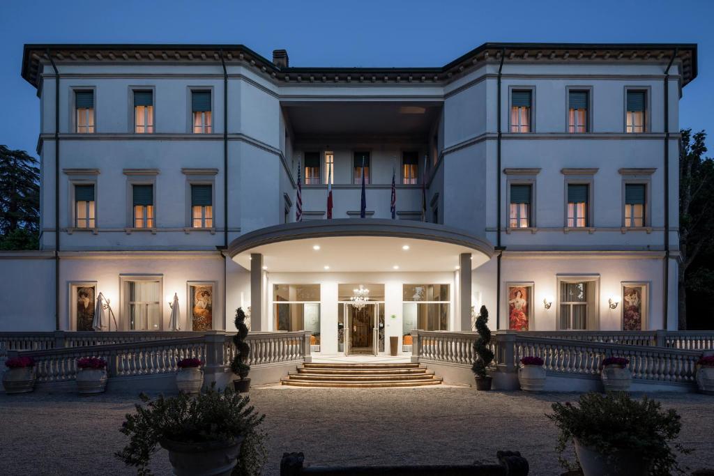 a large white building with stairs in front of it at Grand Hotel Terme in Riolo Terme