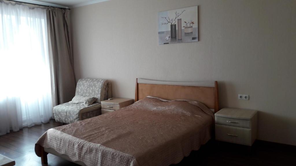 クルィヴィーイ・リーフにあるApartment LUX 95 kvartalのベッドルーム1室(ベッド1台、椅子、窓付)