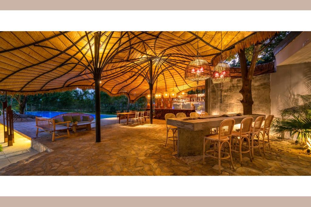 a patio with a table and chairs and a bar at Qingyuan Zhilin Hot Spring Bed and Breakfast in Qingyuan