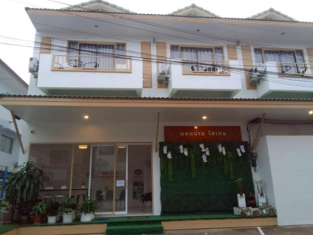 eine Ladenfront eines weißen Gebäudes mit Fenstern in der Unterkunft Nornnan Hotel in Nan